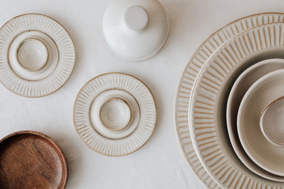 Top view of neutral-toned ceramic plates arranged on a soft cotton cloth for a minimalist aesthetic.