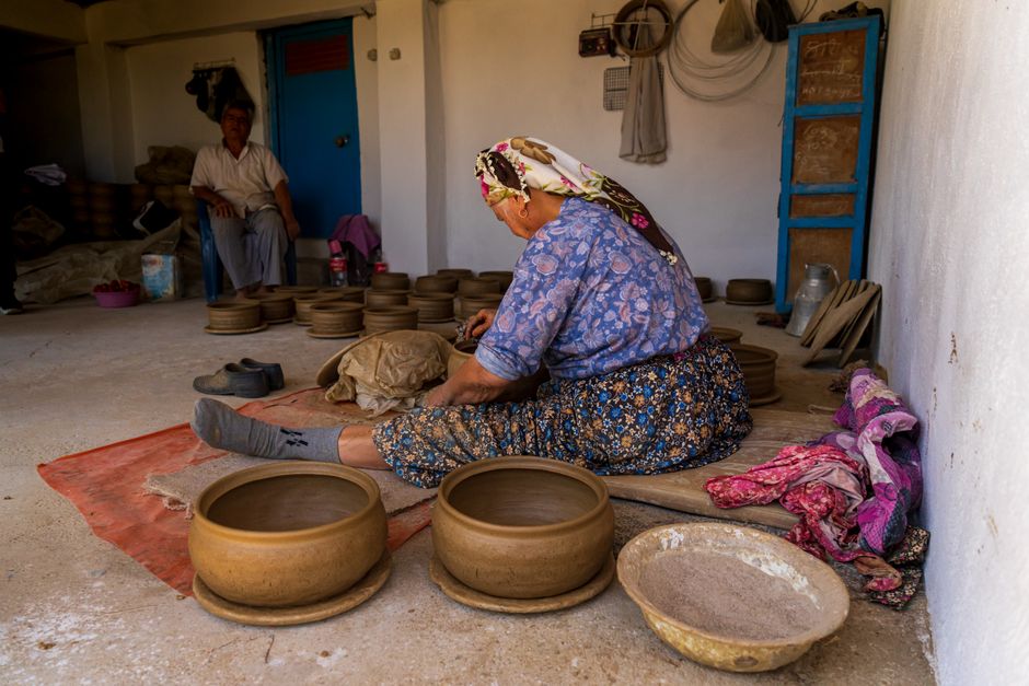 Woman crafting pottery in a rustic workshop, showcasing traditional techniques and cultural heritage.